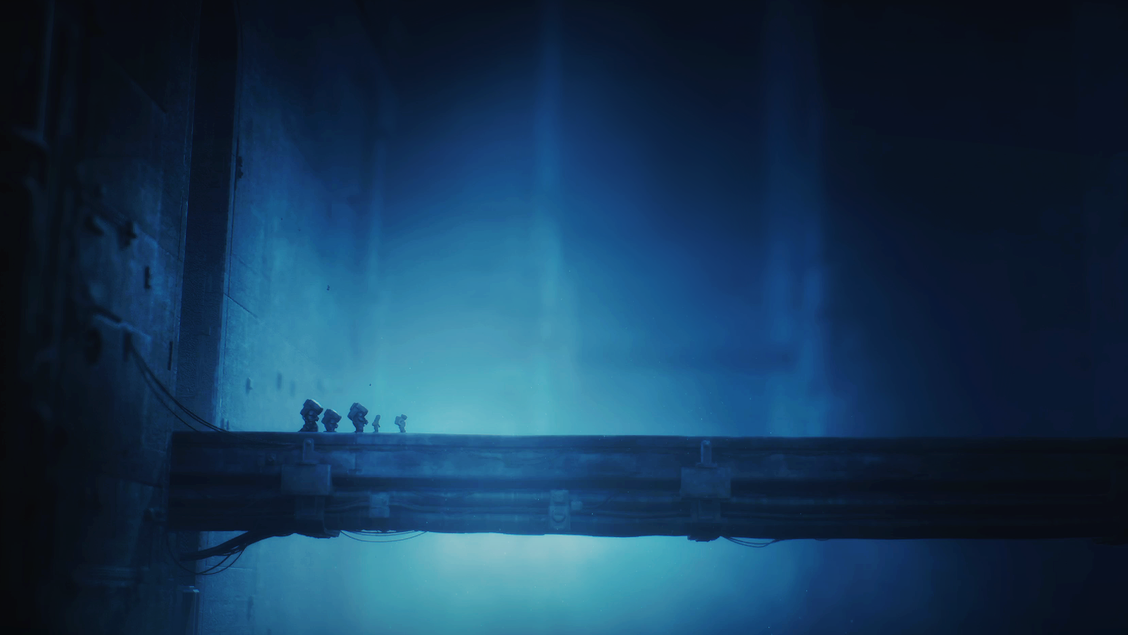 Explorers crossing a suspended bridge in the blue-lit facility